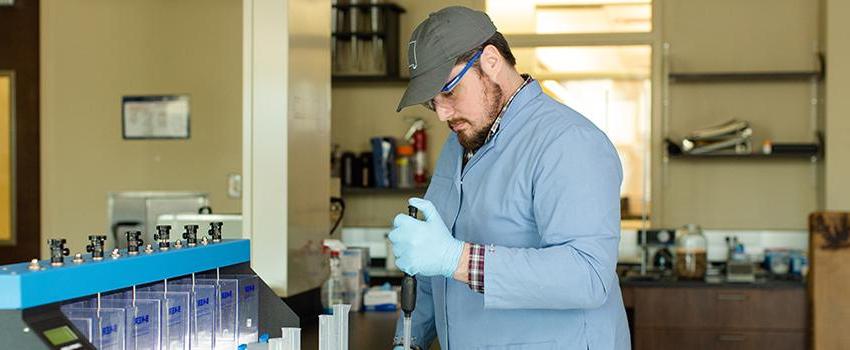 Civil Engineering student using dropper in lab.